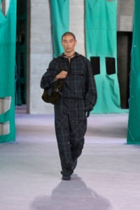 Model wearing Burberry Check viscose silk anorak and cargo trousers in seaweed and inox.