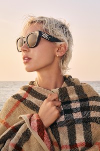 Iris Law 戴着 Burberry 太阳眼镜，裹着格纹浴巾站在沙滩上