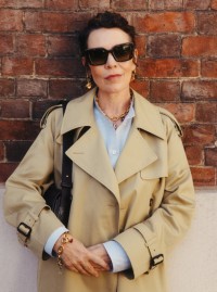 Olivia Colman身穿米色长款卡斯尔福德版型风衣，手持黑色小号B字型卡扣信使包