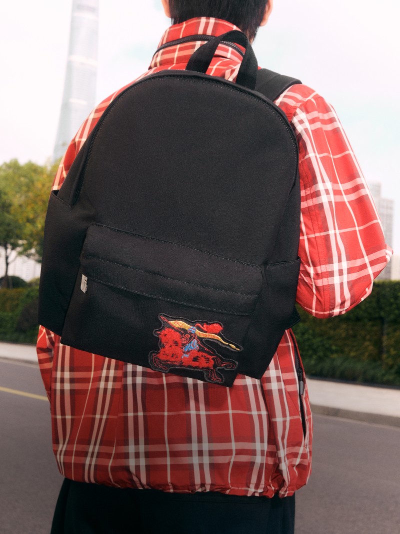 模特身穿Burberry格纹外套，搭配黑色双肩包