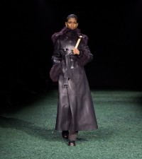 Model in Shearling trim leather trench coat in black