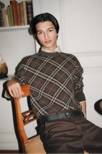 图片中，模特身穿Burberry格纹针织衫，以及丁香棕棉质卡其裤