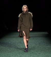 Model in Shearling trim pleated boiled wool dress in glen