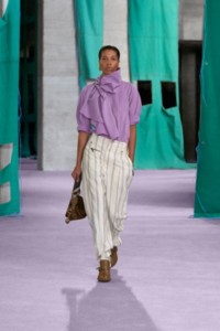 Model wearing striped silk crepe scarf shirt in palma and Striped viscose silk trousers in cotton.