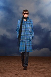 Burberry2026夏季时装秀，模特Noah Bates身穿格纹涂层风衣，搭配黑色针织围巾